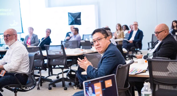 Image of our 2024 Global Forum attendees taking notes and clapping after a presentation.