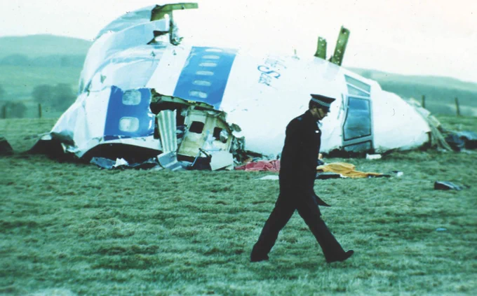 A Scottish Police officer surveys wreckage of Pan Am Flight 103 in Lockerbie, Scotland. 