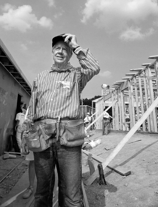 A black and white photo of President Carter at a construction site for Habitat for Humanity.