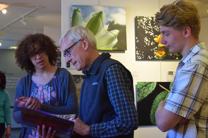 Gov. Evers looks at art at the gallery with student artists. 
