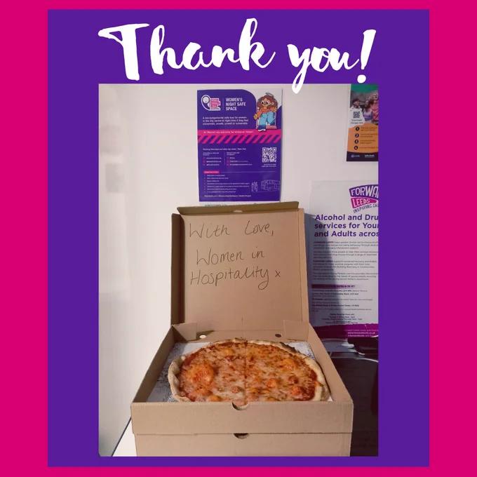 Pizza boxes stacked up, top one open with message written, 'with love, women in hospitality x'