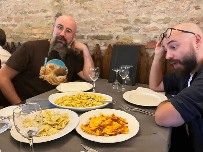 Due autori di Comics&Science, Giovanni Eccher e Gabriele Peddes, sono al tavolo di un ristorante. Di fronte a loro tre piatti di primi. 