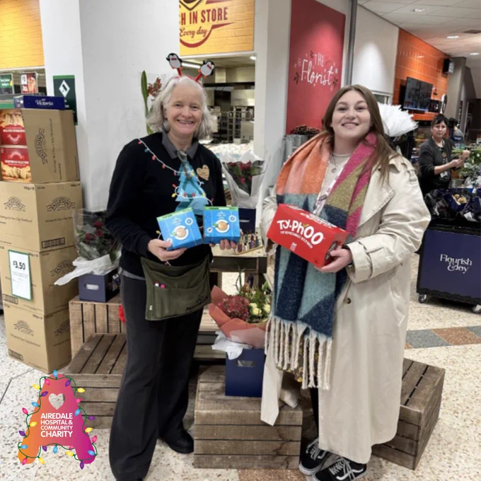 Image of two women holding boxes of tea