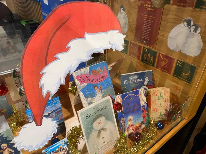 Image shows a Santa hat against the Library’s Christmas book display