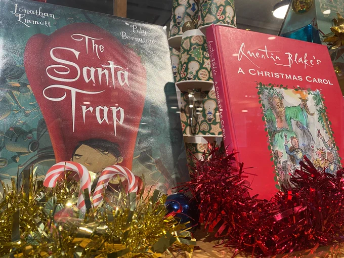 Image shows 2 close up Christmas books with tinsel surrounding them
