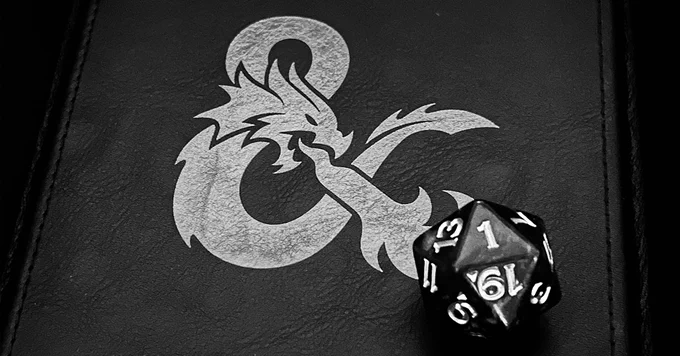 A black and white photo of a Dungeons & Dragons dice tray with a rolled d20 showing a "1" on its face.