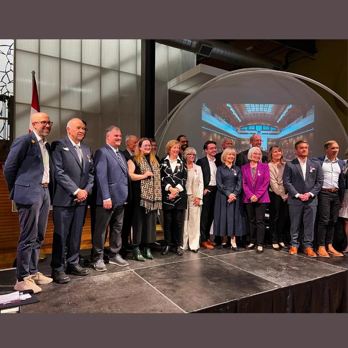 A photo of a group of people standing on a stage.