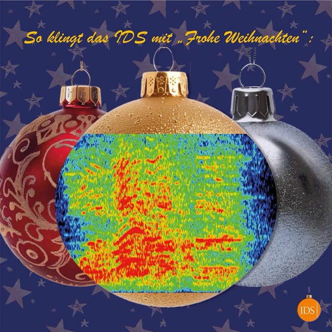 Drei Weihnachtskugeln. Auf der mittleren ist ein Spektrogramm zu sehen, eine Visualisierung der verbalen Äußerung "Frohe Weihnachten". Das Frequenzspektrum ist dabei in verschiedenen Farben visualisiert. Darüber steht: "So klingt das IDS mit 'Frohe Weihnachten".
