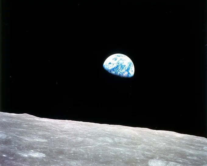 Against the blackness of space, Earth is seen rising over the lunar surface, which is gray and full of craters in the foreground. The lower part of the globe is in shadow, but the rest of Earth is mostly blue water with swirling white clouds and a few patches of brown land. The second image is a cropped-in version with Earth in the center.