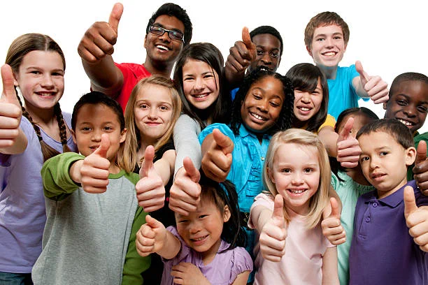 Group of young people from different backgrounds smiling at the camera holding their thumbs up