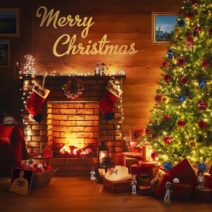 A living room with a fireplace and a Christmas tree. The room is decorated for Christmas and features Braves ornaments and Braves bobbleheads and items throughout the room.