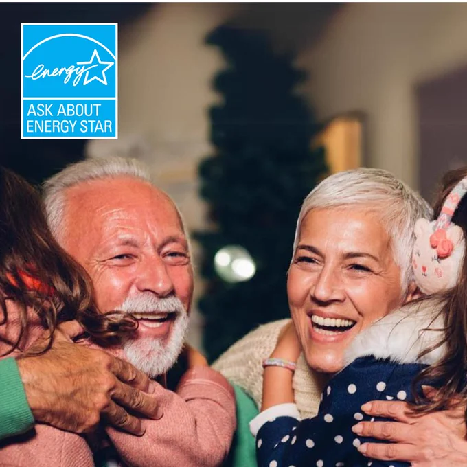 Two grandparents smile as they are hugged by little kids in winter clothes