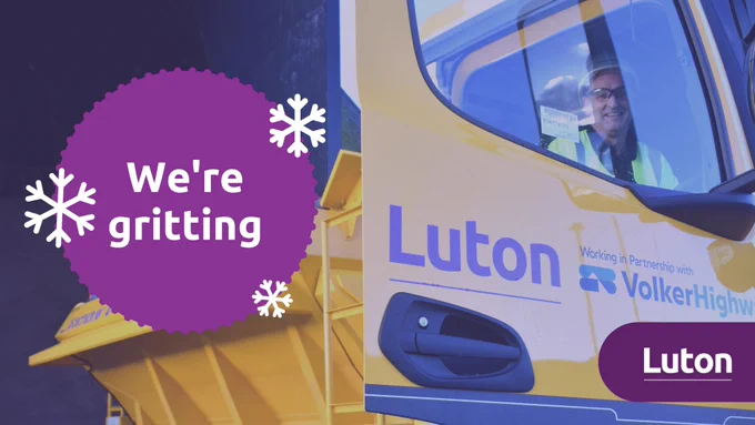 Gritter crew in truck smiling with text that reads "We're gritting"