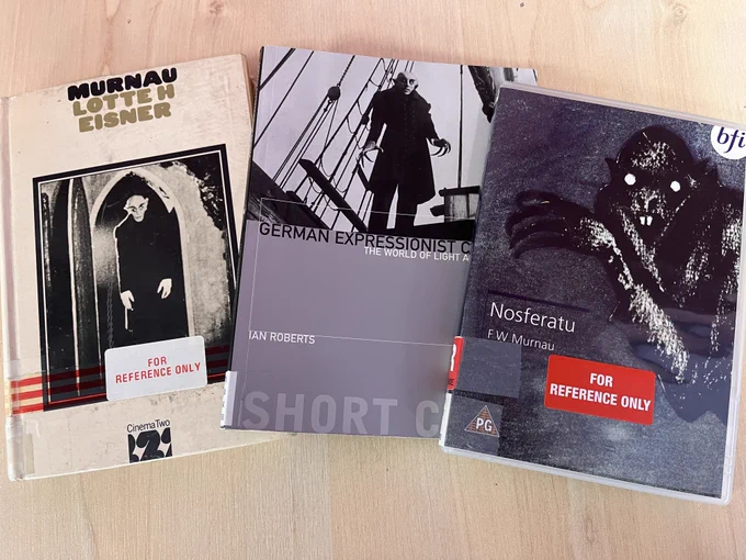Photo of 2 books and a DVD on a table. They are titled "Murnau" by Lotte H Eisner, "German Expressionist Cinema" by Ian Rover, and the DVD is "Nosferatu" by FW Murnau.