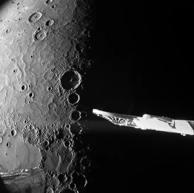 Image taken by BepiColombo during its sixth Mercury flyby. Planet Mercury is visible in the background with its grey, cratered, pock-marked surface. In the foreground are some spacecraft parts.
