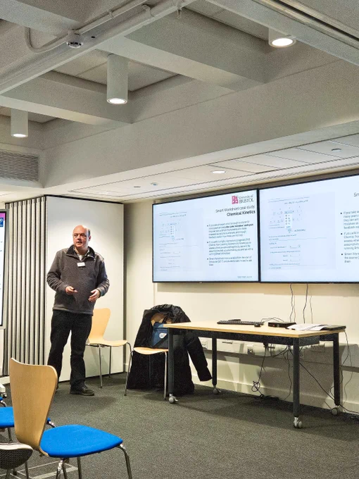 Prof Dudley Shallcross mid-presentation, standing in front of a projector screen, which is showing an example of a Smart Worksheet. 