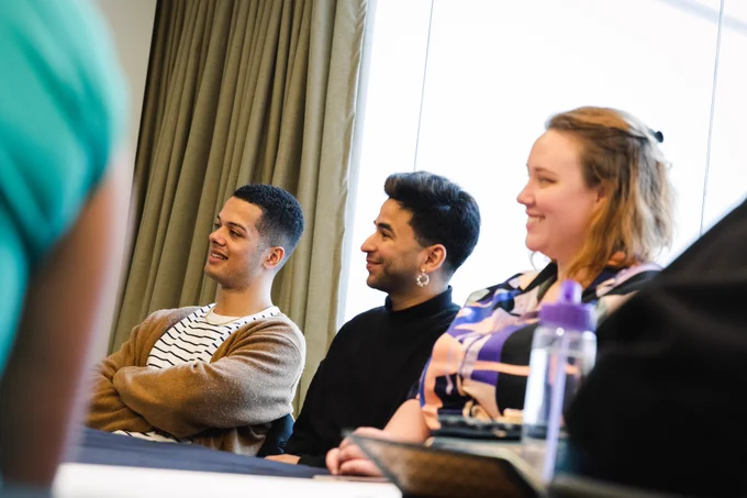 Three previous BFI Flare mentees sat in a mentoring session smiling to the left of the photo at something off-camera.
