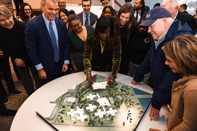 Mayor Cherelle L. Parker and group looking over a model of the new Riverview Wellness Village