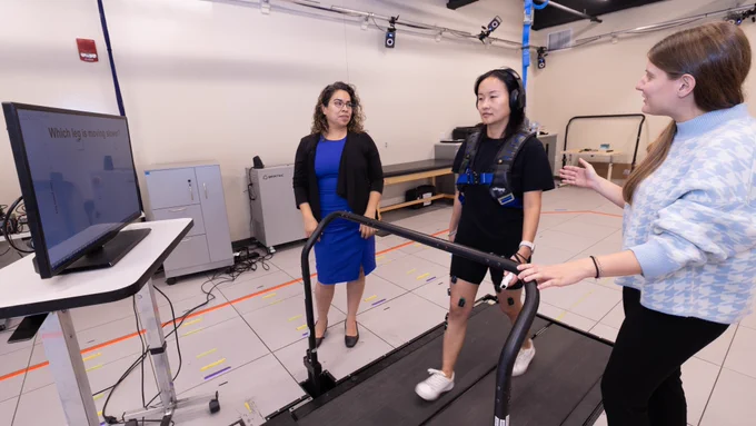 Gelsy Torres-Oviedo in her lab, overseeing a student demonstration on a split-belt treadmill