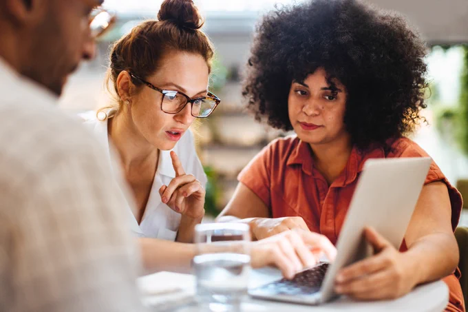A group of employees looking at a laptop screen 