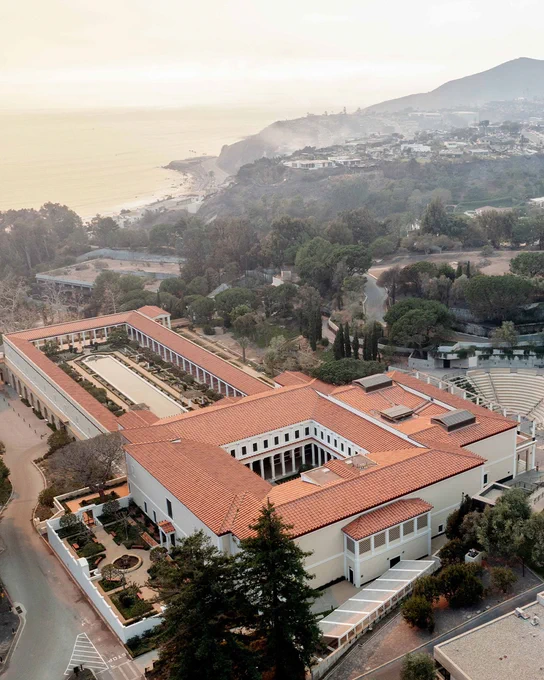 A drone shot of the Getty Villa museum building against the landscape overlooking the ocean