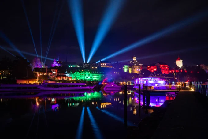 Farbig beleuchtete Stadt Murten vom See aus gesehen (Bild: Murten Tourismus)