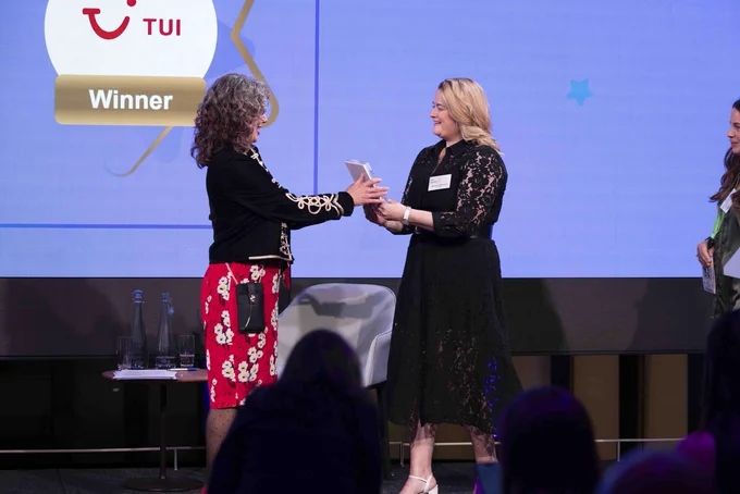 An event host handing an award to a guest on stage at an event.
