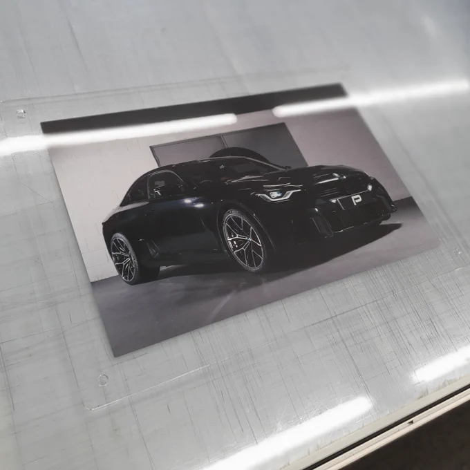 Photo of a black BMW M2 G87 mounted on a clear acrylic panel.