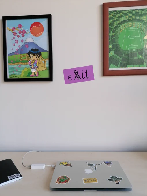 Zwei gerahmte Bilder über einem Tisch mit Laptop 
