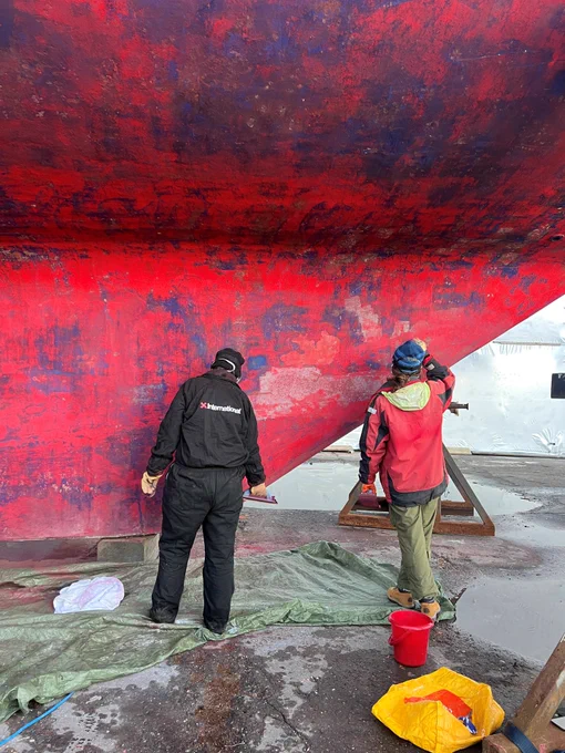Two people working to get the hull cleaned and sanded for antifouling