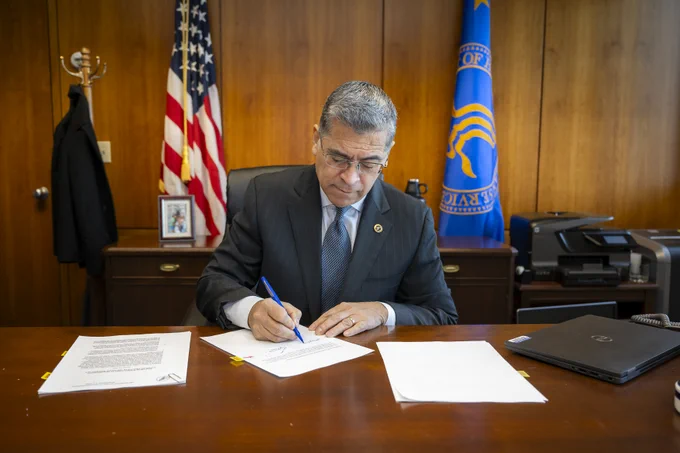 Secretary Becerra signing PHE