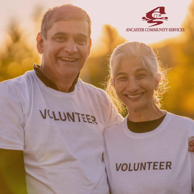 Photo of 2 adults wearing t-shirts that say VOLUNTEER.