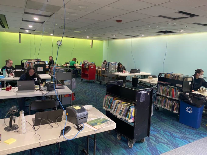 AADL staff hard at work relabeling some of the 50,000 books that will be relabeled and reshelved during the closure. 10 relabeling stations fill the story corner with carts of books and supplies everywhere!