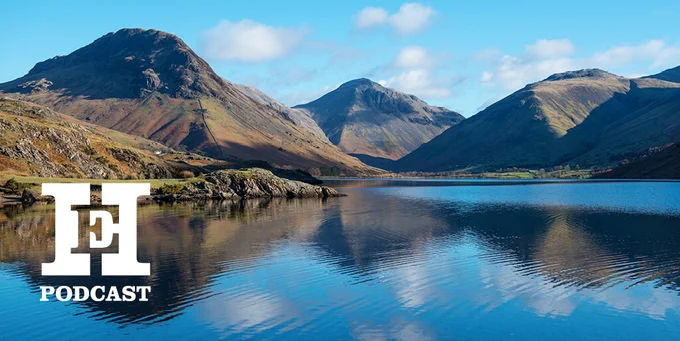 Podcast banner featuring a serene landscape with a calm lake reflecting mountains under a clear blue sky. The HistoryExtra podcast logo is displayed prominently on the image.