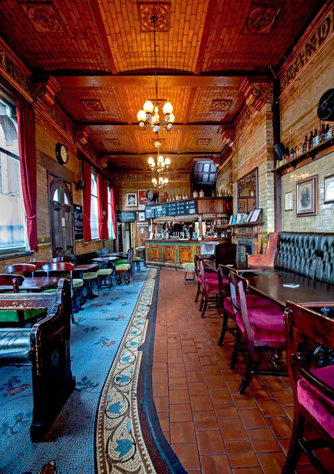 The beautifully tiled and wooden interior of the Marble Arch pub in Manchester