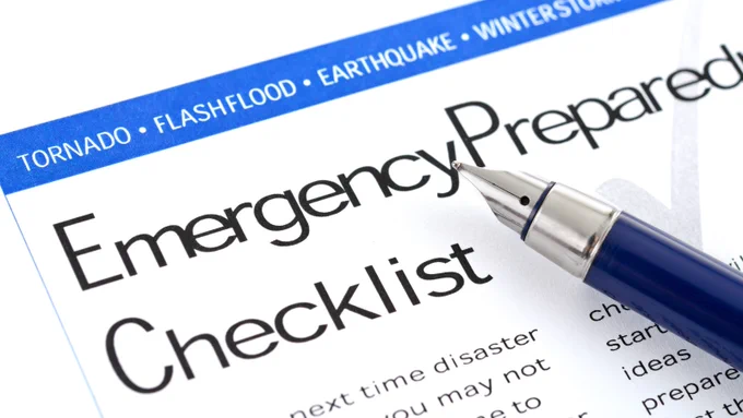 A close-up of an emergency preparedness checklist with a pen resting on it.