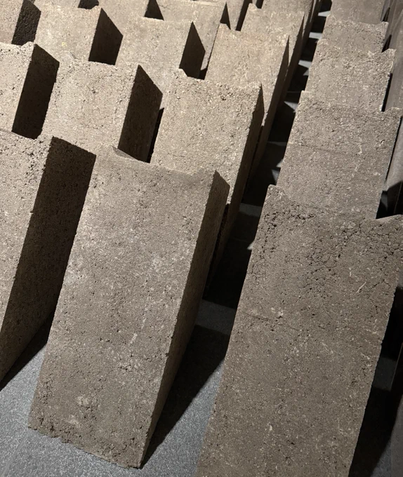 Close-up view of an art installation featuring multiple vertical concrete blocks arranged in a repetitive, geometric pattern.