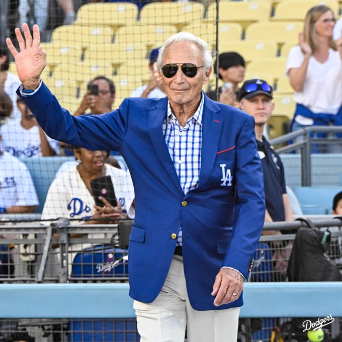 Sandy Koufax walks on the field at Dodger Stadium and waves to the crowd.