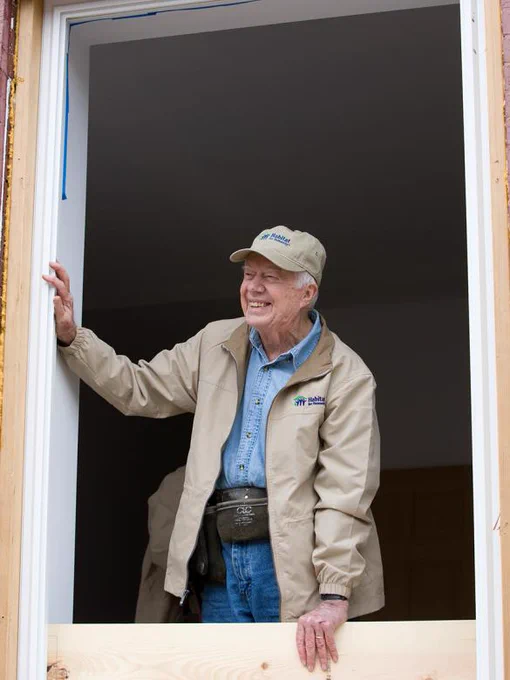President Jimmy Carter looks out of a window at a past Carter Work Project. 