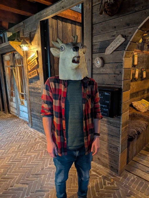 A man with a deer head faces the camera