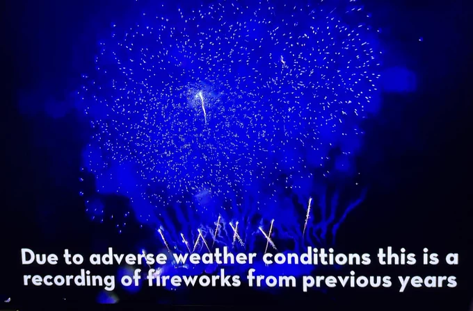 Screenshot: a firework display with caption “due to adverse conditions this is a recording from previous years”