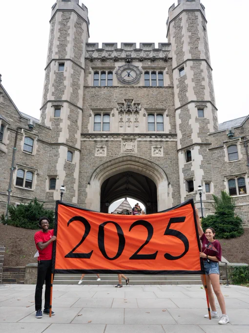 Two students holding a banner with "2025" in front of Blair Arch.