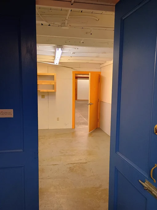 An open blue door, looking through to an empty room with an open orange door.