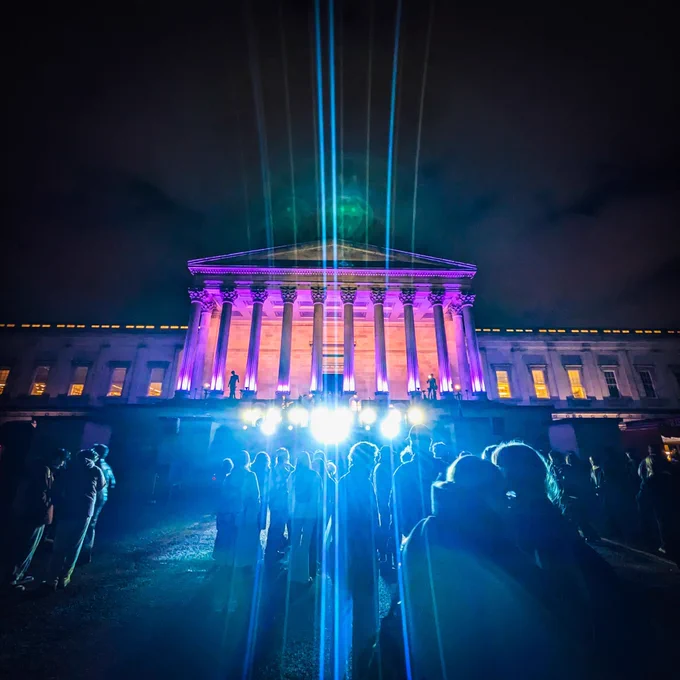 UCL portico lit up in purple at night 