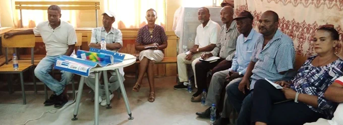 Group of eight adults sitting in a meeting room, with some documents and a table. Solomon Teshome is pictured with other members of the Dire Dawa Fiscal Transparency and Accountability Cluster. 