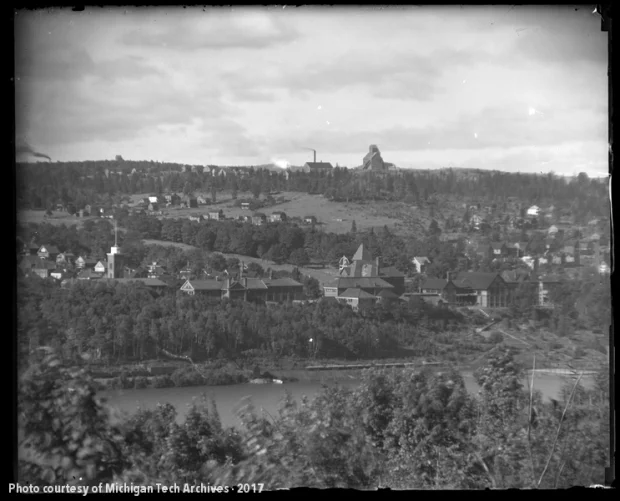 Image of college campus with a mine shafthouse atop a hill behind it