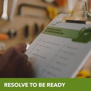 A hand marking a paper checklist of preparedness items