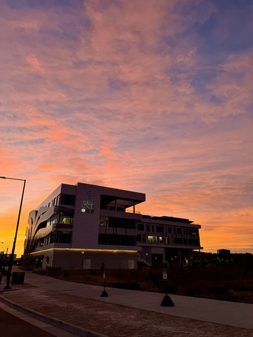 The CSU Spur Hydro building with a large picturesque sunset in the background
