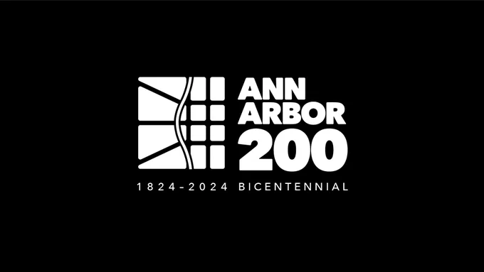 The Ann Arbor 200 Logo, white on a black background, showing the river, the Native trails that became Miller, Huron, and Liberty, and the street grid that followed. Text reads Ann Arbor 200: 1824-2024 Bicentennial.