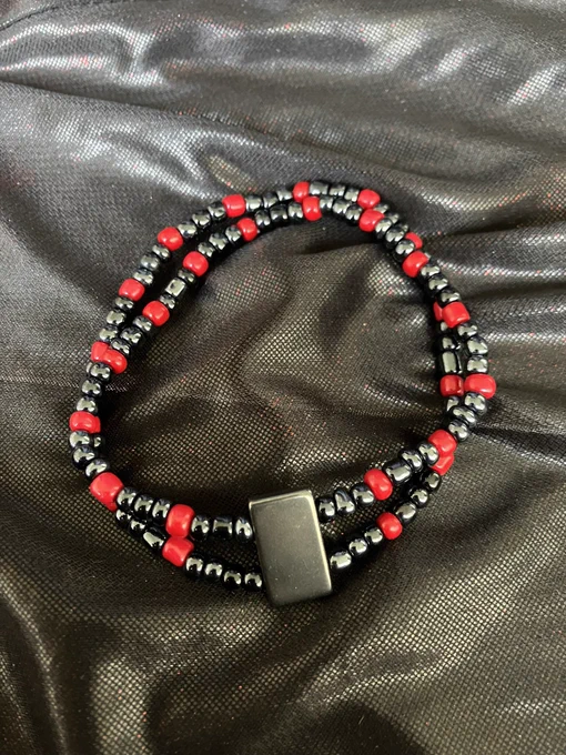 Two-tiered bracelet with a magnetic hematite centerpiece and black chrome and red glass seed beads. Braclet is beaded on elastic thread and is 4 inches in diameter with a decent amount of stretch